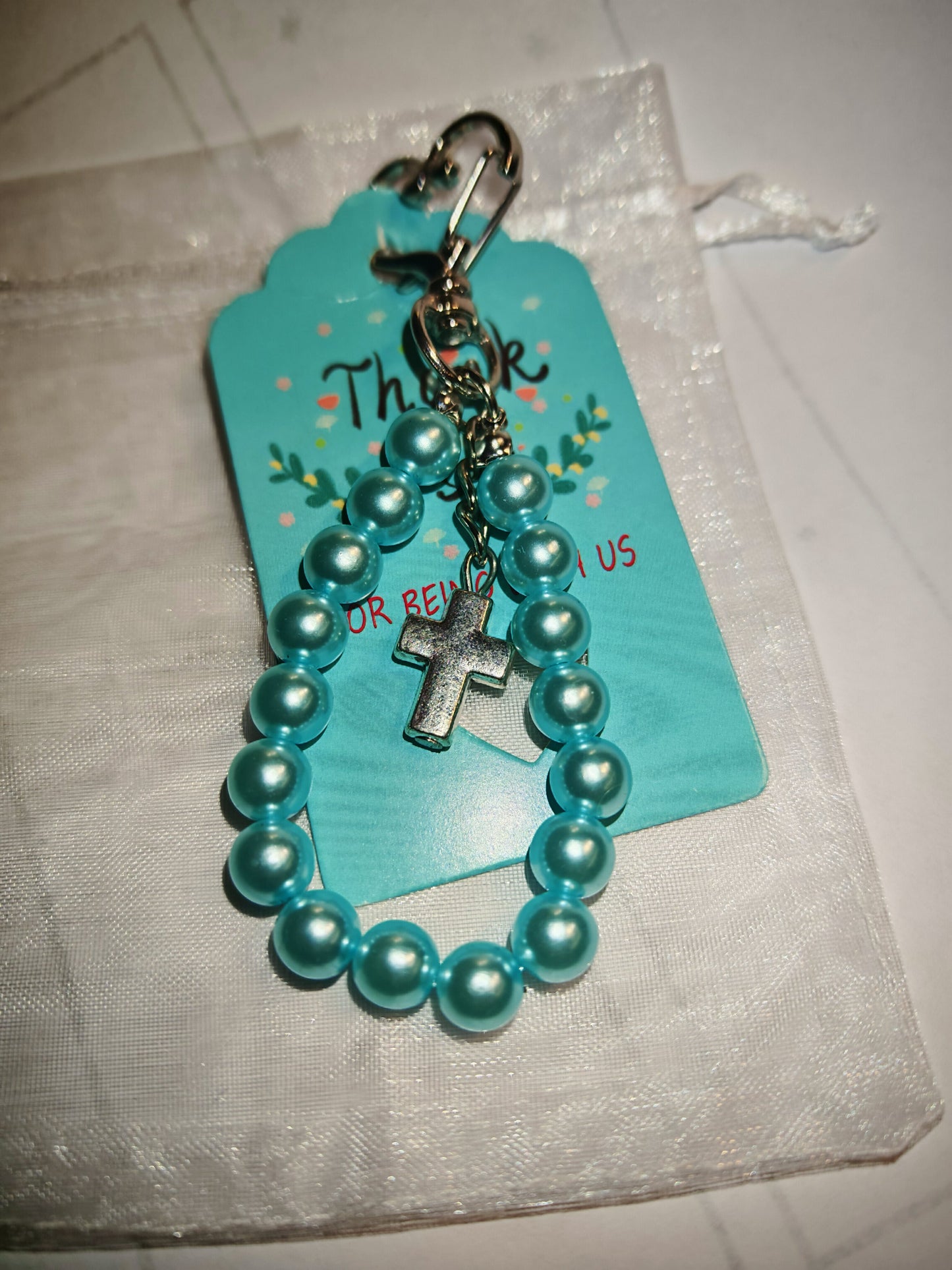Porte-clés religieux artisanal – Perles turquoise & croix argentée
